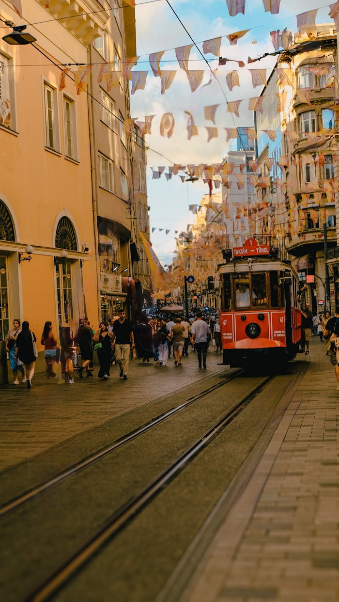 gallery-4 Vintage red tram in bustling Istanbul street with people and festive decorations.