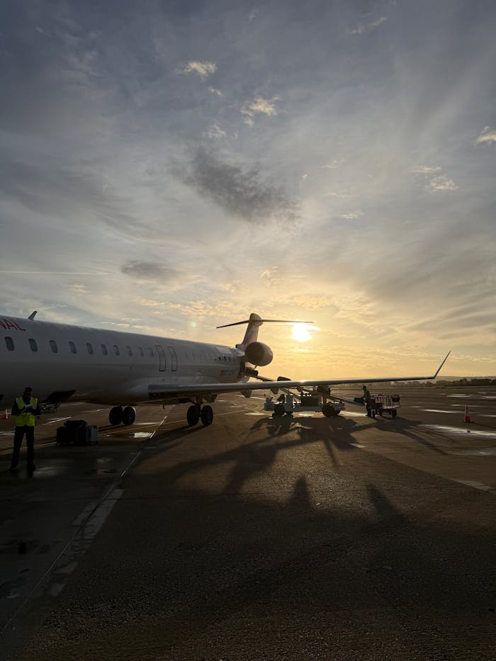 Airplane on runway during sunset, capturing serene sky and soft lighting.